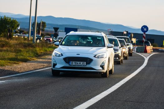 Traveling white Ford car in motion on asphalt road, front view of car on street. Bucharest, Romania, 2020