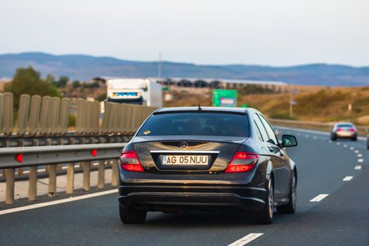 Traveling Mercedes car in motion on asphalt road, back view of car on street. Bucharest, Romania, 2020