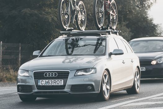 Traveling white Audi car in motion on asphalt road, front view of car on street. Bucharest, Romania, 2020