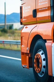 Side view of loaded European truck in motion on asphalt road, transportation and delivery concept. Detail on delivery truck. Bucharest, Romania, 2020