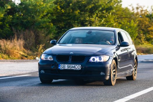 Traveling BMW car in motion on asphalt road, front view of car on street. Bucharest, Romania, 2020