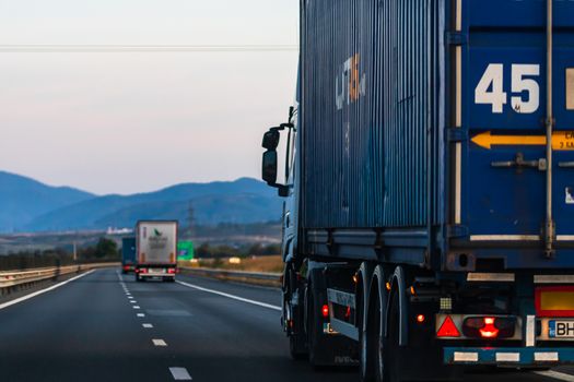 Side view of loaded European truck in motion on asphalt road, transportation and delivery concept. Detail on delivery truck. Bucharest, Romania, 2020