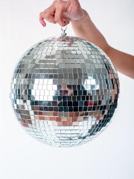 Hand holding Shining Disco Ball dance music event equipment isolated on white background