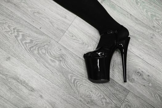 Hhigh boots on platform and heel. Feet and shoes on the parquet floor during training