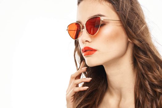 Portrait of brunette woman in sunglasses naked shoulders light background. High quality photo