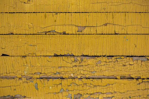 Yellow color painted weathered wooden horizontal planks texture with vertical craquelures
