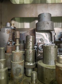 A lot of old rusted machining stock holders dark industrial background with selective focus.
