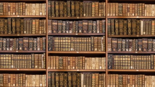Defocused and blurred image of old antique library books on shelves for use in video conferencing background and sized to 16:9 format