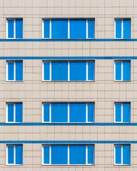 Fragment of the modern office building with blue mirrored windows.