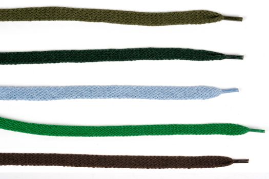 Collection of colored cotton laces for shoes with tip on white background