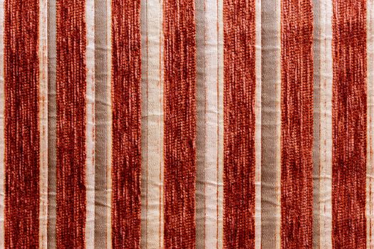 red vertical striped synthetic woven upholstery fabric close-up texture and background