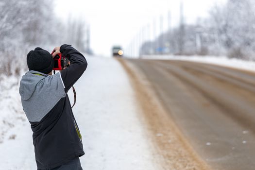photographer shoot on the road at winter daylight with srlrctive focus.