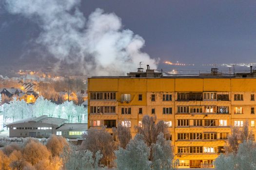 russian province high rise block house roof with steam cloud.