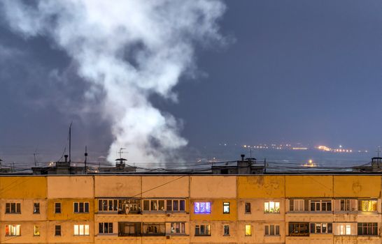russian province high rise block houseroof with steam cloud.