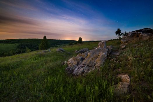 night glacial stones in field landscape under moonlight