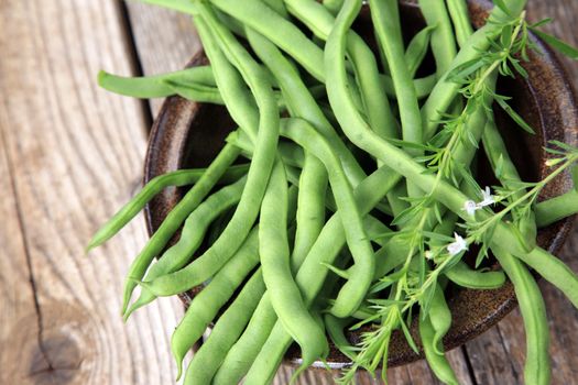 Many green beans in a brown bowl