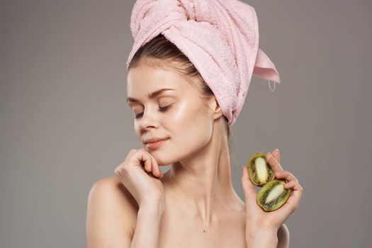 beautiful woman naked shoulders kiwi in the hands of spa treatments. High quality photo