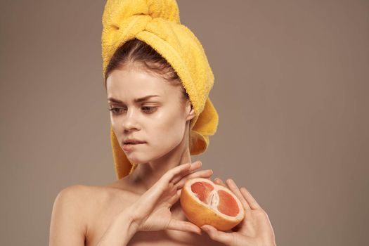 Pretty woman bared shoulders grapefruit in hand natural cosmetics vitamins. High quality photo