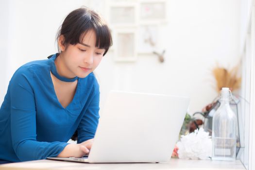 Beautiful portrait asia young woman working online on laptop sitting at cafe shop, professional female freelance using notebook computer, business and communication concept.