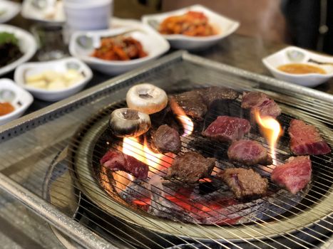 Grill meat on hot coals. This kind of food is a Korean or Japanese BBQ style.