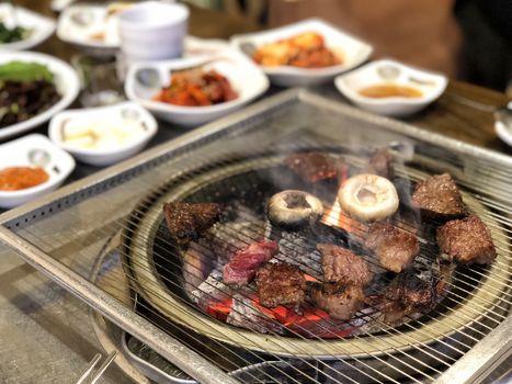 Grill meat on hot coals. This kind of food is a Korean or Japanese BBQ style.