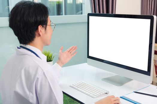 Asian young handsome doctor man wearing a doctor's dress and stethoscope video conference call or facetime raise hand say hello to patient he smiling on desk at hospital office, Health medical care