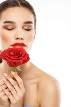 charming brunette girl with makeup on her face and a red rose in her hand. High quality photo