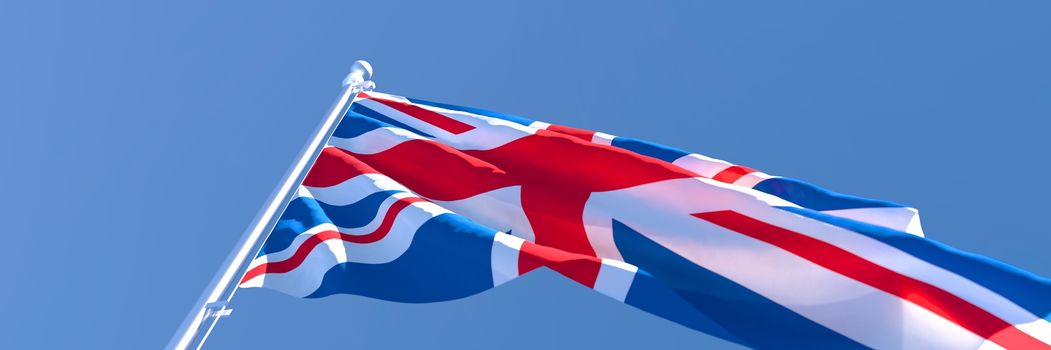 3D rendering of the national flag of British waving in the wind against a blue sky