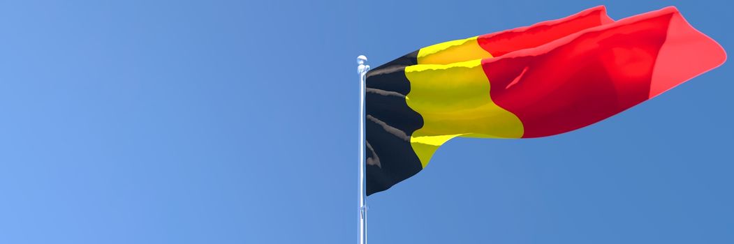 3D rendering of the national flag of Belgium waving in the wind against a blue sky
