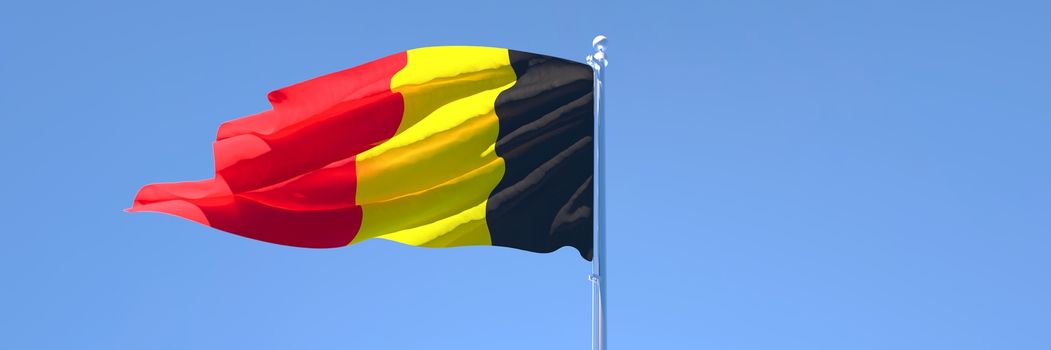 3D rendering of the national flag of Belgium waving in the wind against a blue sky