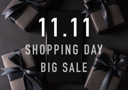 11:11 sale shopping concept, Top view of gift box wrapped black paper and black bow ribbon present around a smartphone with 11.11 shopping and big sale text, studio shot on dark background11:11 sale shopping concept, Top view of gift box wrapped in black paper and black bow ribbon with 11.11 single's day and big sale text at the side space, studio shot on dark background