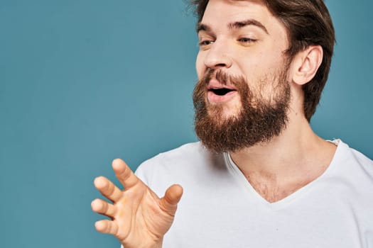 emotional man gesturing with hands lifestyle fun white t-shirt blue isolated stock. High quality photo