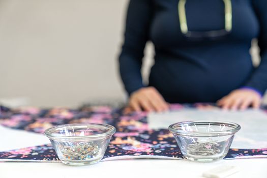 needles in a bowl on a sewing table in a tailor shop.