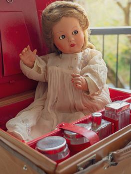 Vintage doll in a vintage red suitcase.