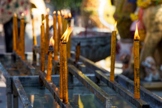 Thailand dog temple, Wat Ket Karem, with votive lighted candles with statues and sleeping dogs and votive offerings. High quality photo