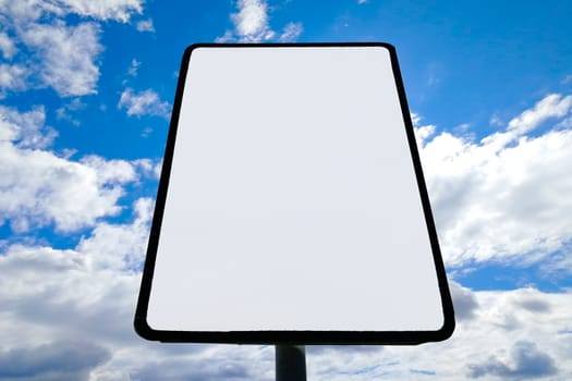 road sign against clouds and sun. City