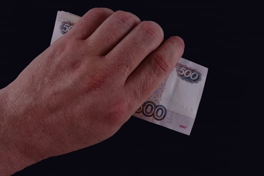 In the hand of the banknote on dark background