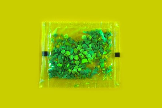Plastic bag with spices on a yellow background