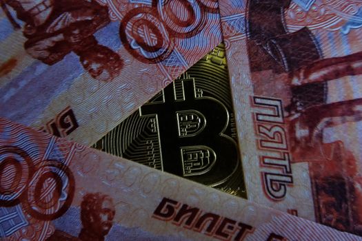 Bitcoin in the middle of paper money, top view.