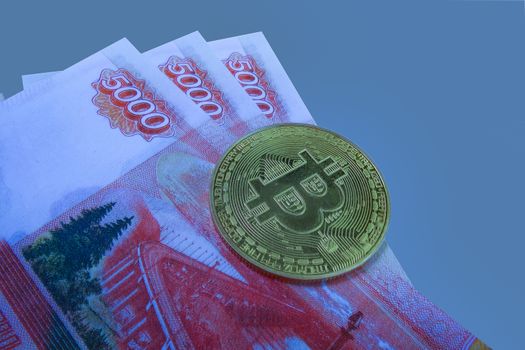 Bitcoin coin on a wad of money. Top view