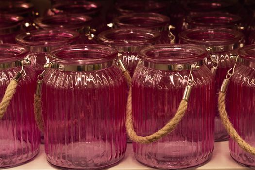 Pink glass jars with a handle. In A row.