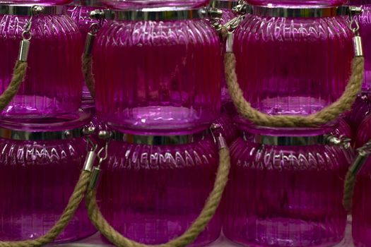 Pink glass jars with a handle. In A row.