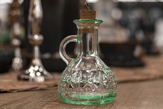 Glass transparent carafe with cork on served table.