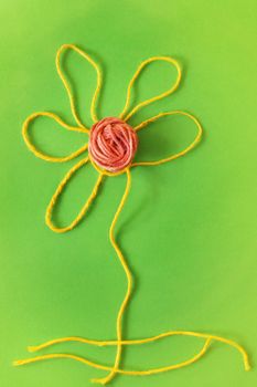 Funny flower made using thread , symplicity and stylization to create a long stem petals and the flower head , studio shot 