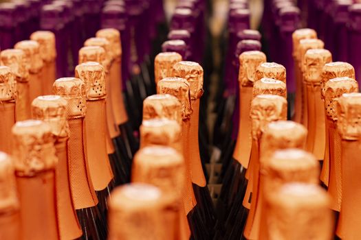 Champagne bottles tops arranged in store shelf. Front view.