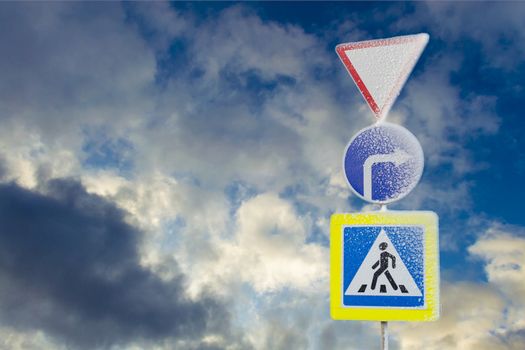 Pillar with road signs againstclouds of sky. View from below.