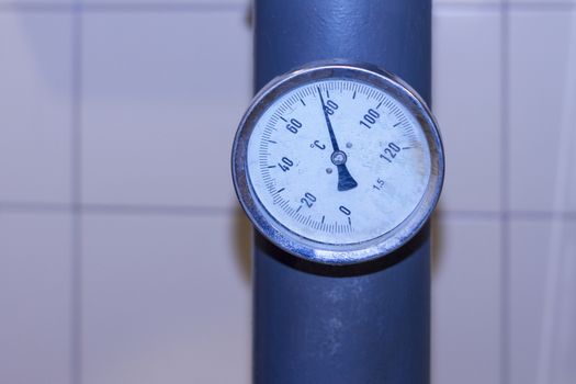 Temperature sensor is analog on chimney heating of an industrial building. View from the front.