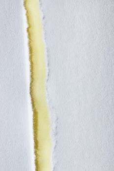 A white ripped paper rests on a yellow background ,beautiful paper edge , top view