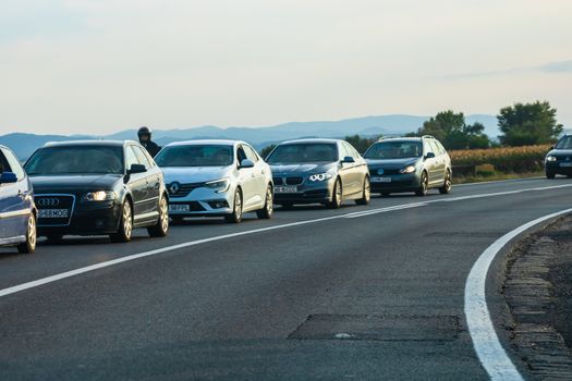 Traveling cars in motion on asphalt road, front view of cars in row on street. Bucharest, Romania, 2020