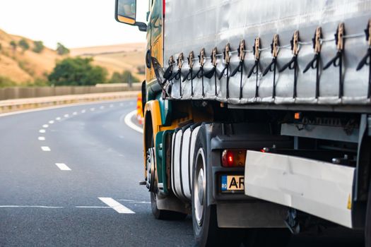 Side view of loaded European truck in motion on asphalt road, transportation and delivery concept. Detail on delivery truck. Bucharest, Romania, 2020